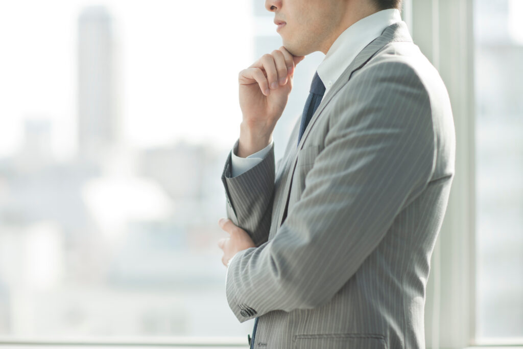 職場で悩みながら今後の働き方について考えている日本人会社員。