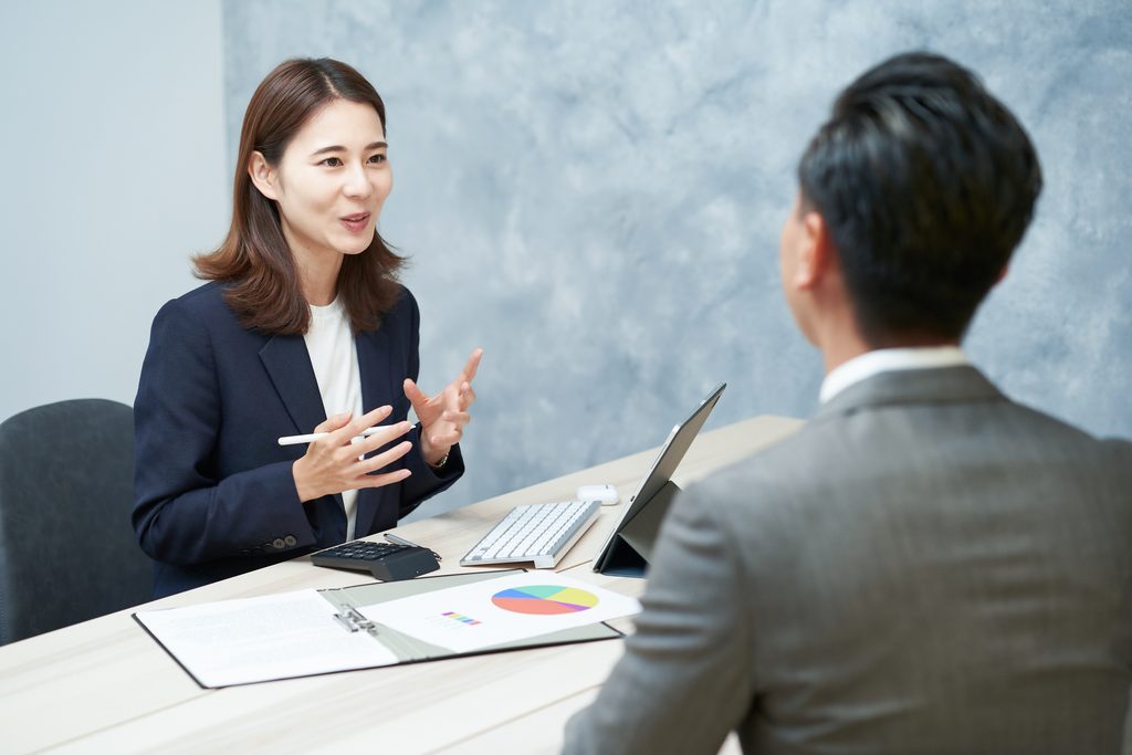 日本人の相談者と相談を受ける人が、テーブルを挟んで落ち着いて話している様子。